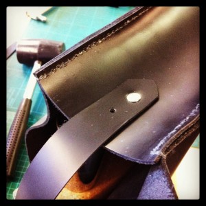 attaching the strap with metal rivets...